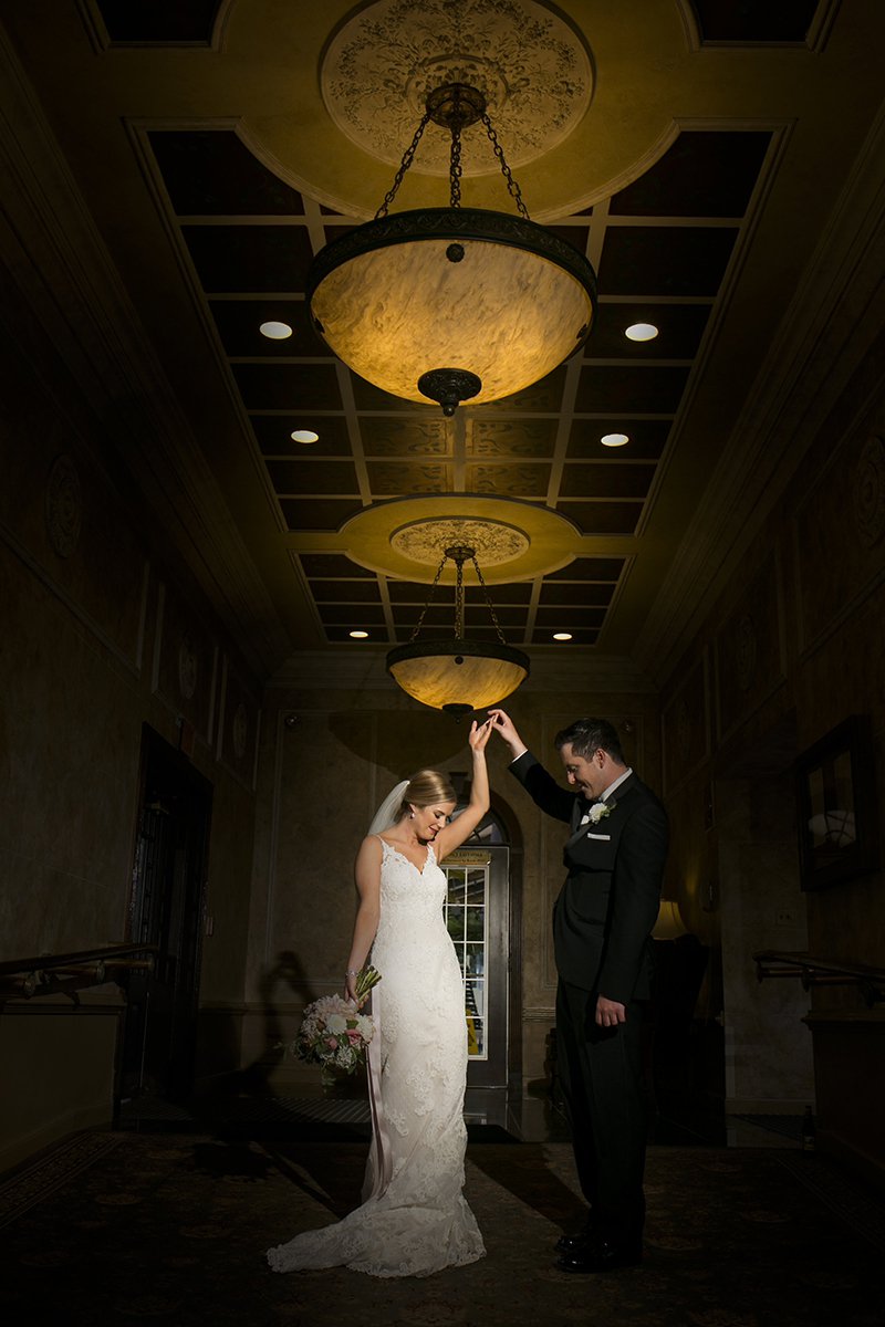 Bride and groom making their entrance in a hotel hallway with dramatic lighting