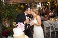 Bride and groom kissing after cutting wedding cake