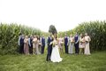 Group photo of bridal party in corn field