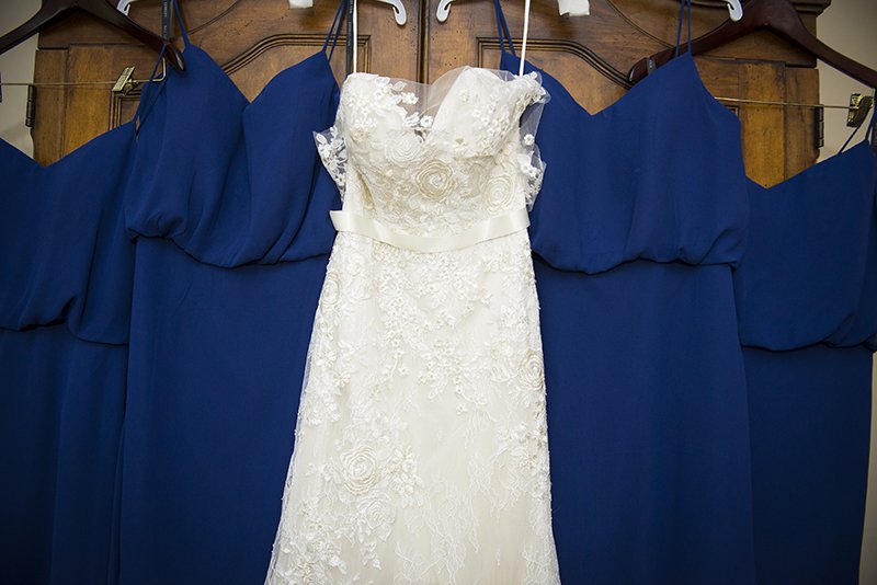 White lace bridal gown and wedding dresses arranged on hangars
