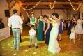 Bridal party dancing with small children on parquet floor at wedding reception