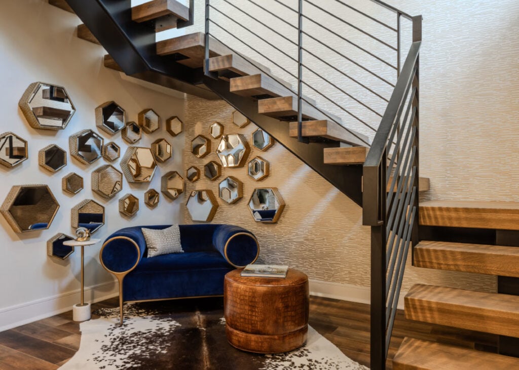 A blue velvet chair surrounded by gold hexagonal mirrors in an Upper Saucon house