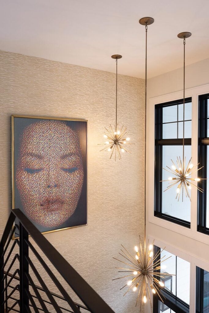 Wall art and chandeliers at the top of the stairs in an Upper Saucon house